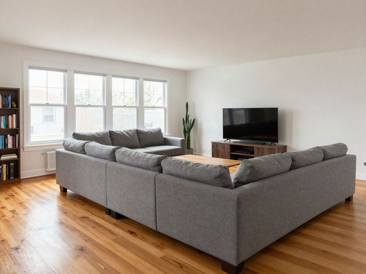 A shared living room with a sofa, a TV and a window onto the porch